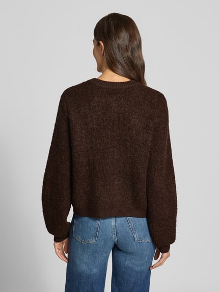 Frauenmodel trägt Strickjacke aus Viskose-Mix Modell 'Taile Nerida' von MSCH Copenhagen in Dunkelbraun, feine Textur, Ganzkörperansicht Rückansicht. Damen Strickjacke, Relaxed Fit, Rundhalsausschnitt, Knopfleiste, Woll-Anteil, Rückenlänge 54 cm, Ärmellänge 66 cm.