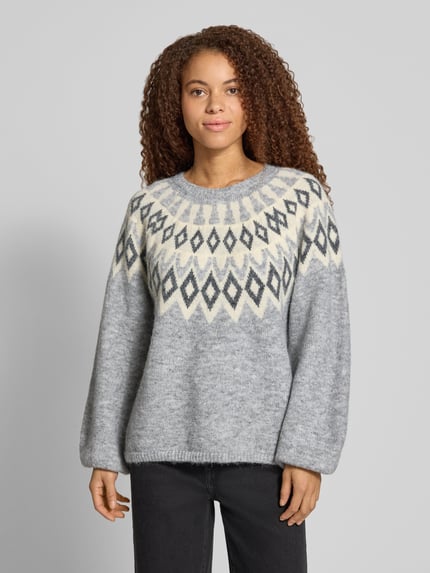 Frauenmodel trägt Pullover mit Jacquardpasse von ONLY in Strickoptik, grau meliert, geometrisches Rautenmuster, Ganzkörperansicht von vorne.
