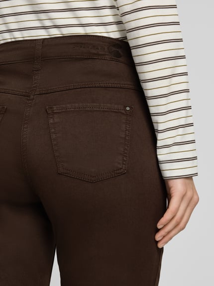 Kobieta nosi brązowe jeansy Straight Fit Jeans aus Baumwoll-Mix Modell 'Dream' od MAC, tekstura gładka, zbliżenie na tył, damskie jeansy MAC