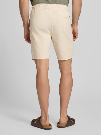 Männermodel trägt Regular Fit Shorts aus Baumwoll-Leinen-Mix Modell 'LINUS' von Only & Sons, efekt: jednolity kolor, aplikacja z metką, elastyczny ściągacz z tunelem, wpuszczane kieszenie i kieszeń z tyłu, mieszanka bawełny i lnu, Ganzkörperansicht Rückansicht.