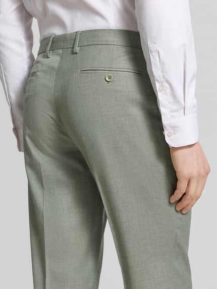 Männermodel trägt Anzughose mit Bügelfalten und Gesäßtaschen von Christian Berg Men aus Material-Mix mit Viskose-Anteil in Hellgrau, Ganzkörperansicht Rückansicht.