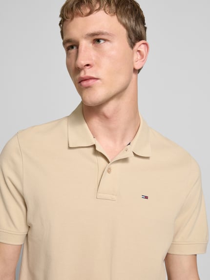 Mannenmodel draagt Regular Fit Poloshirt uit puur katoen van Tommy Jeans, look: effen, gestikt logo, polokraag, korte mouw, piqué, nahaufnahme bovenlichaam.