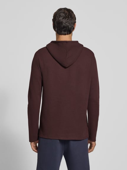 Männermodel trägt Relaxed Fit Sweatshirt aus Baumwoll-Mix Modell 'Waffle LS' von BOSS in Dunkelrot, strukturierte Oberfläche, Ganzkörperansicht Rückansicht, Herren Hoodie von BOSS.