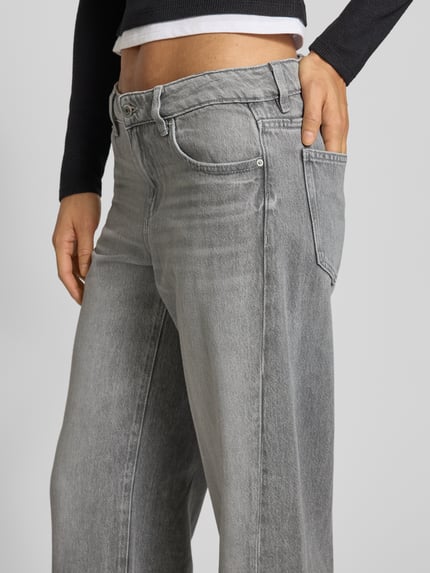 Vrouwenmodel draagt Wide Fit Jeans im 5-Pocket-Design mit Lyocell-Anteil van Gina Tricot, mix van katoen en lyocell, knoop- en ritssluiting, 5-pocketmodel, bandwijdte maat 36: 42 cm, binnenbeenlengte maat 36: 80 cm, grijs met lichte wassing, detailopname heup en bovenbeen.