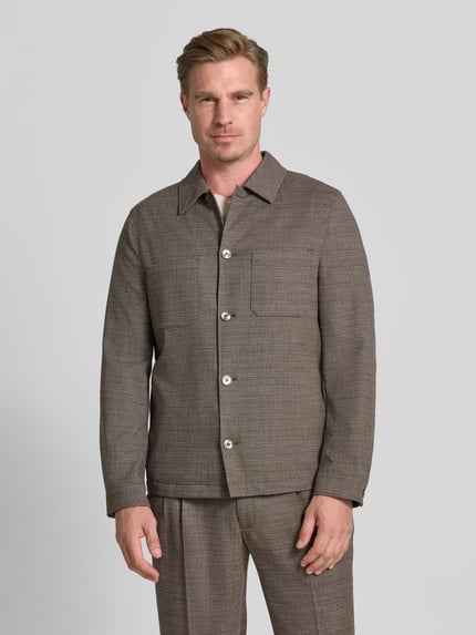 Männermodel trägt Hemdjacke mit Brusttaschen von MCNEAL in Braun-Grau, Material-Mix mit Viskose-Anteil, Gerader-Schnitt, Kentkragen, Knopfleiste, Rückenlänge bei Größe M 70 cm, Ganzkörperansicht von vorne.