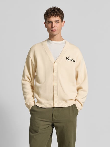 Männermodel trägt Oversized Wolljacke aus Woll-Mix von KENZO in Creme mit Knopfleiste und Stickerei, Nahaufnahme Oberkörper, Herren Wolljacke Woll-Baumwoll-Mix, Szerokość w rozmiarze M: 62 cm, długość tyłu: 68 cm, długość rękawa: 61 cm