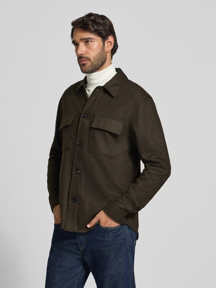 Męski model nosi Regular Fit Hemdjacke mit Kentkragen und Brusttaschen von Profuomo, ciemnobrązowy materiał z domieszką wełny, guziki, kieszenie na piersi, krój regular fit, szerokość w rozmiarze M: 76 cm, zdjęcie w całej sylwetce z przodu.