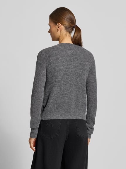 Frauenmodel trägt Regular Fit Strickjacke aus Alpaka-Mix mit Baumwoll-Anteil von DRYKORN, Modell LOBAIA, meliertes Grau, Rückenansicht, Ganzkörperansicht Rückansicht.