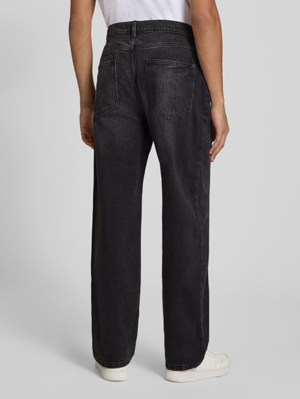 Mężczyznamodel nosi Baggy Jeans in schwarzer Waschung und klassischem 5-Pocket-Design von REVIEW, mieszanka bawełny i elastanu, czarny kolor, krój baggy, 5 kieszeni, zapięcie na guzik i zamek błyskawiczny, szerokość w rozmiarze 32: 42 cm, długość wewnętrzna nogawki w rozmiarze 32: 76 cm, widok całej sylwetki od tyłu.