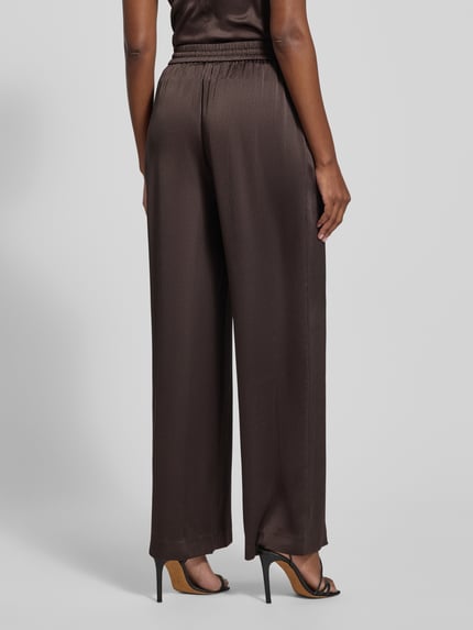 Frauenmodel trägt Stoffhose mit elastischem Bund Modell 'HELENA' von Samsøe Samsøe aus Material-Mix mit Stretch-Anteil, lockerer Schnitt, Tunnelzug, französische Eingrifftaschen, Bundweite 35 cm, Innenbeinlänge 78 cm, Ganzkörperansicht Rückansicht.