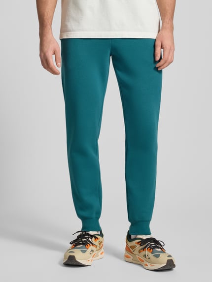 Männermodel trägt Sweatpants mit elastischem Bund von PUMA PERFORMANCE aus Baumwoll-Mix, Türkis, Label-Stitching, Nahaufnahme Unterkörper.