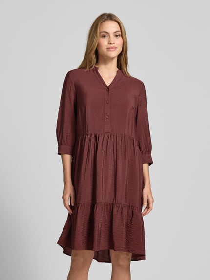 Vrouwenmodel draagt Relaxed Fit midi-jurk uit viscosemix met tuniekhals, knoopsluiting en halflange mouwen van Christian Berg Woman, ruglengte maat 36: 106 cm, borstwijdte maat 36: 45 cm, mouwlengte maat 36: 44 cm, geheel vooraanzicht.