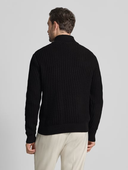 Männermodel draagt Regular Fit Troyer in Waffel-Struktur Modell 'TOM' van SELECTED HOMME in zwart, gebreid katoen. Ganzkörperansicht Rückansicht.