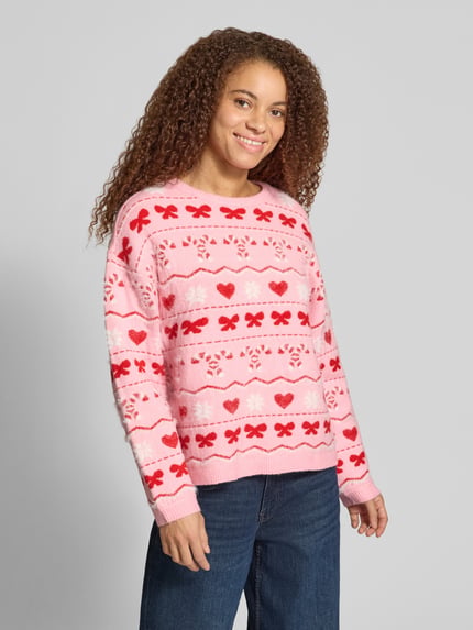 Frauenmodel trägt Pullover mit Santa Schriftzug von ONLY, mehrfarbige Strickoptik, Motiv-Print, Rundhals, langarm, gerippte Abschlüsse, Ganzkörperansicht von vorne.