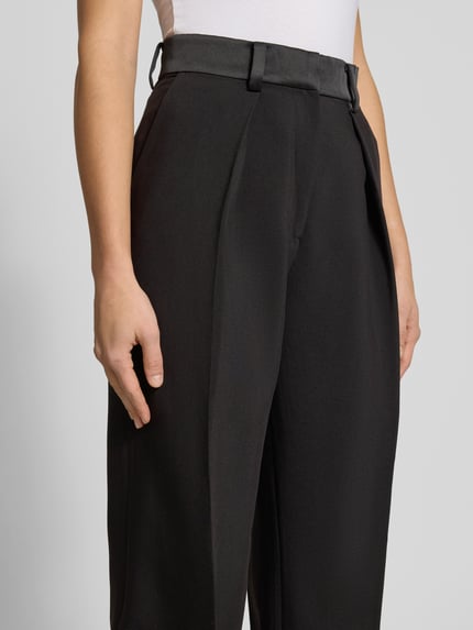 Frauenmodel trägt High Rise Stoffhose mit Gesäßtaschen von Bardot, schwarzer Material-Mix mit Viskose-Anteil, Bügelfalten, Nahaufnahme Oberkörper.