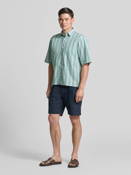 Männermodel trägt Regular Fit Freizeithemd mit Kentkragen und Brusttasche von Lindbergh, grün gestreift, reine Baumwolle, Ganzkörperansicht von vorne.