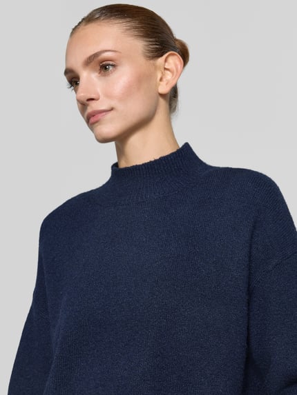 Modelka nosi Turtleneck-Pullover mit Woll-Anteil und Rundhalsausschnitt od Neo Noir, mieszanka materiałów z dodatkiem wełny, prążkowany okrągły dekolt, prosty krój, prążkowane wykończenia, ciemnoniebieski, struktura dzianiny, Nahaufnahme górnej części ciała.