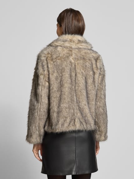Kobiece modelka nosi beżowo-brązową kurtkę z sztucznego futra z kieszeniami marki B.Young, model 'Jacke aus Kunstfell mit Eingrifftaschen Modell 'AKAJA', regular fit; widok całej sylwetki z tyłu.