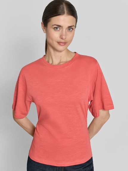 Modelka nosi T-Shirt mit 1/2-Arm und Raffungen von Jake*s Casual, damski t-shirt z bawełny, dopasowany krój, okrągły dekolt, rękaw o dł. 1/2, marszczenia, długość tyłu w rozmiarze S: 54 cm, widok na górną część ciała z przodu.