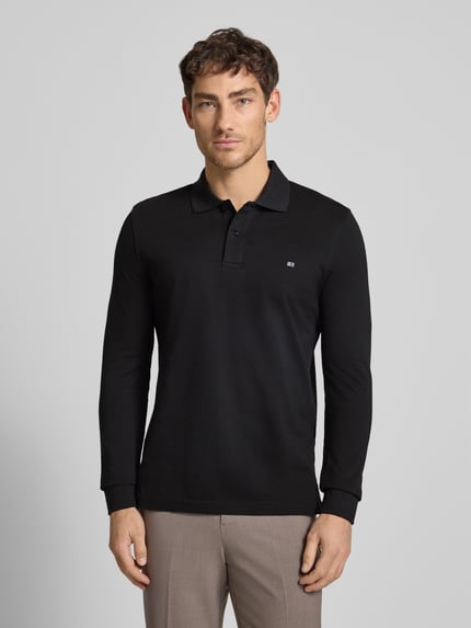 Męski model nosi czarne Poloshirt mit Label-Stitching Modell 'PAXTON' od Christian Berg Men, bawełna, slim fit, widok z przodu, ujęcie całej sylwetki.