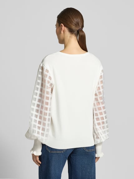 Frauenmodel trägt Strickpullover aus Viskose-Mix mit Rundhalsausschnitt von Apricot, weiße Farbe, semitransparente Ärmel, Rückenansicht, Kontext: Damen Strickpullover, Regular Fit, Rückenlänge 23 cm, Ärmellänge 26 cm.