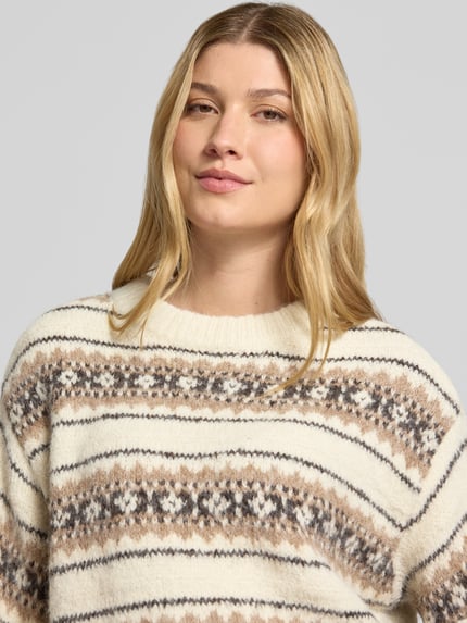 Frauenmodel trägt Pullover mit gerippten Abschlüssen von VERO MODA, mehrfarbiges Allover-Muster in Strickoptik, Nahaufnahme Oberkörper.