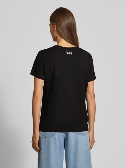 Frauenmodel trägt Regular Fit T-Shirt mit Label-Emblem Modell 'Dala' von MOS MOSH in Schwarz, glatte Jersey-Struktur, Ganzkörperansicht Rückansicht, Damen T-Shirt, Rundhalsausschnitt, kurzärmelig, Rückenlänge S 58 cm.