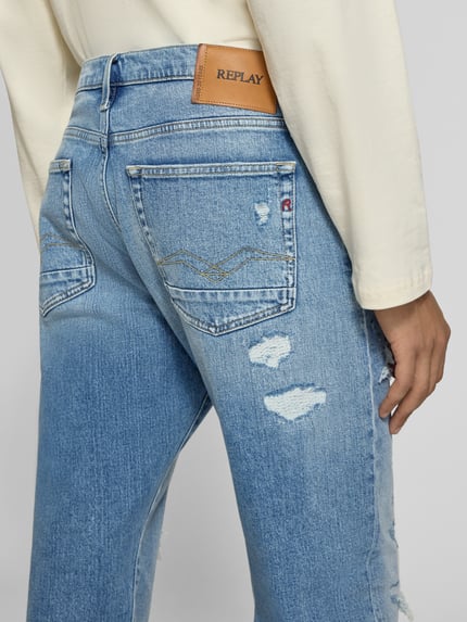 Mannenmodel draagt Straight Fit jeans in destroyed-look Model 'AIDEEN' van Replay, mix van katoen en elastaan, detailopname achteraan. Bandwijdte maat 32/32: 44 cm, binnenbeenlengte: 79 cm.