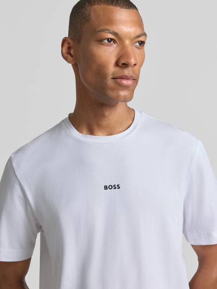 Männermodel trägt T-Shirt mit Label-Print von BOSS, weiß, Regular Fit, Rundhalsausschnitt, Baumwoll-Elasthan-Mix, Nahaufnahme Oberkörper.