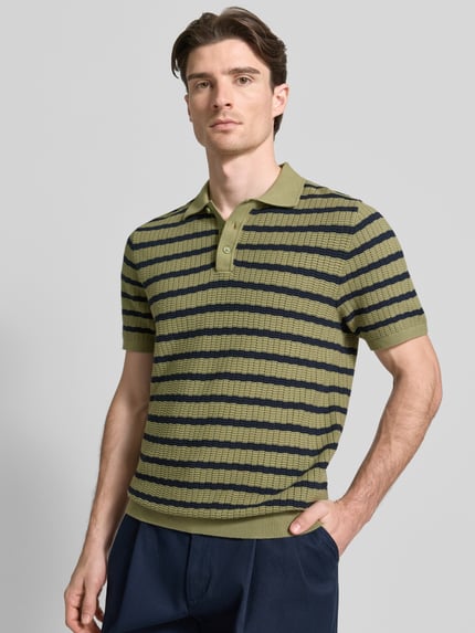 Männermodel trägt poloshirt met polokraag en korte knoopsluiting van MCNEAL, puur katoen, regular fit, ruglengte maat M 70 cm, mouwlengte 26 cm, groene kleur met donkerblauwe strepen, structuur met fijne textuur, ganzkörperansicht van voren.