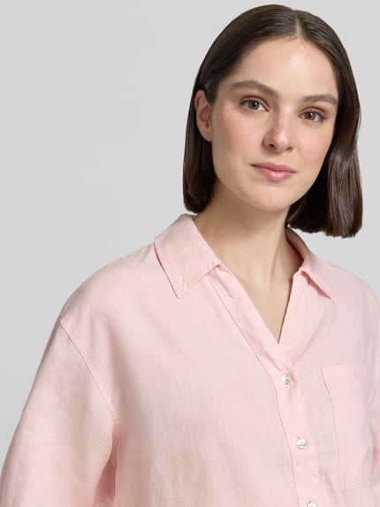 Frauenmodel trägt Regular Fit Leinenbluse mit Brusttasche Modell 'Flippa' von OPUS in zartem Rosa, reines Leinen, Nahaufnahme Oberkörper.