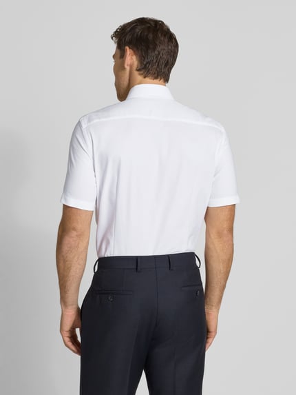 Męski model nosi Slim Fit Business-Hemd mit Kentkragen od Jake*s, biały bawełniany miks z domieszką stretchu, krój slim fit, kołnierz kent, listwa guzikowa, długość pleców w rozmiarze 39/40: 83 cm, szerokość ramion w rozmiarze 39/40: 41 cm, długość rękawa w rozmiarze 39/40: 26 cm, tekstura gładka, widok całej sylwetki od tyłu.