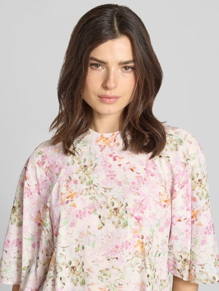 Frauenmodel trägt Blusenshirt aus Viskose Modell 'Brina' von JOOP! mit floralem Muster, lockerem Schnitt und Stehkragen, Nahaufnahme Oberkörper.