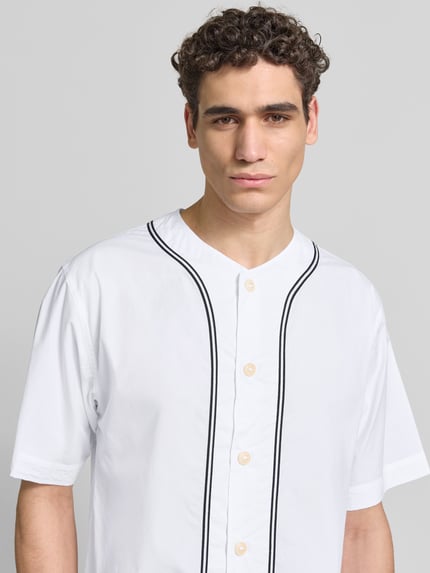 Männermodel trägt Freizeithemd in kurzärmeligem Design von Kenzo aus reiner Baumwolle, Relaxed-Fit, Rundhalsausschnitt, Knopfleiste, weiß mit schwarzen Linien, Nahaufnahme Oberkörper.