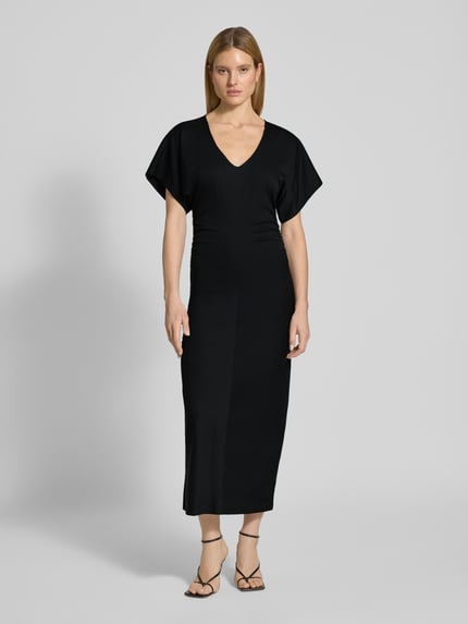 Vrouwenmodel draagt figurbetontes Maxikleid met V-hals Model 'PAMANTI' van Drykorn, lyocellmix met stretch, nauw aansluitend model, ruglengte bij maat S 136 cm, borstwijdte 36 cm, mouwlengte 17 cm, zwart, gladde stof, eenvoudige vormen, ganzkörperansicht van voren.