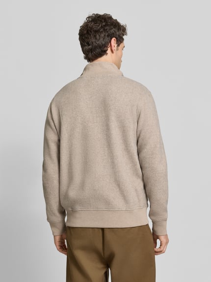 Männermodel trägt Strickjacke aus Wolle mit Stehkragen von RAGMAN in Beige, strukturierte Optik, gerippte Abschlüsse, Ganzkörperansicht Rückansicht.