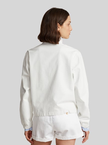 Modelka nosi Regular Fit Blouson aus reiner Baumwolle od Polo Ralph Lauren, biały, prosty fason, długi rękaw, widok całej sylwetki z tyłu.