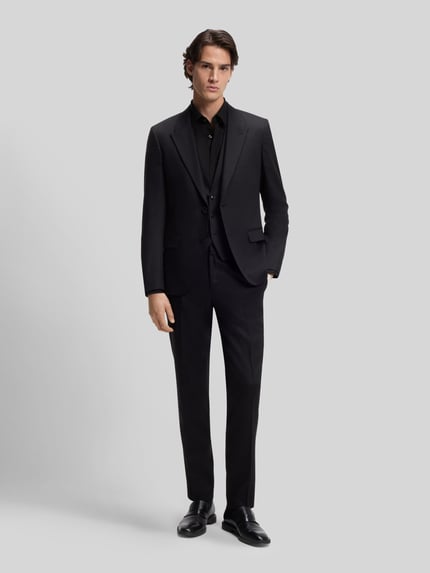 Mężczyzna model nosi Slim Fit Freizeithemd aus Baumwoll-Mix Modell 'ERMO' von HUGO, krój slim fit, jednolity kolor, widok całej sylwetki z przodu.