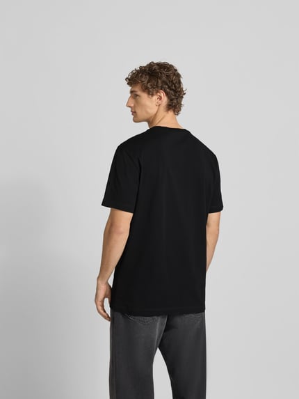 Männermodel trägt Loose Fit T-Shirt mit Logo-Print von Dsquared2 aus reiner Baumwolle in Schwarz, Rückenansicht, Ganzkörperansicht Rückansicht.