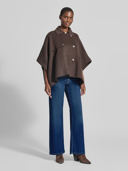 Frauenmodel trägt Wide Leg Jeans aus Baumwoll-Mix Modell 'AIMEE' von CAMBIO in Blau, kombiniert mit braunem Cape, Damen Wide & Loose Fit Jeans, Ganzkörperansicht von vorne.