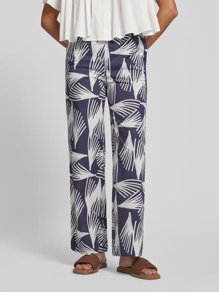 Frauenmodel trägt Wide Fit Stoffhose mit floralem Allover-Print Modell 'Lani' von GUIDO MARIA KRETSCHMER WOMAN in Dunkelblau und Weiß aus reiner Baumwolle mit elastischem Bund und Tunnelzug, florales Allover-Muster, Ganzkörperansicht von vorne.