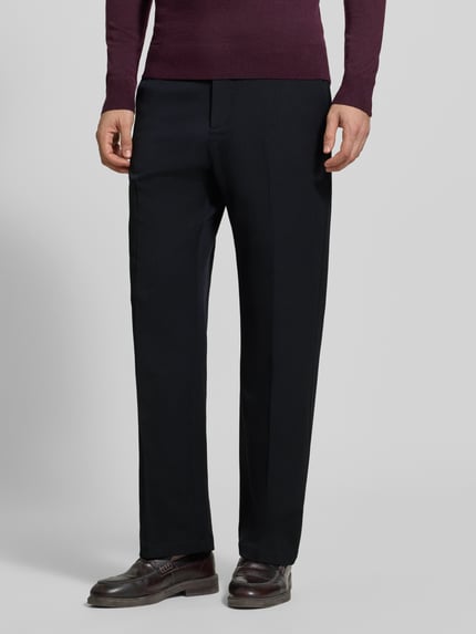 Männermodel trägt Stoffhose mit Bügelfalte und Eingrifftaschen von Les Deux, schwarze Farbe, gerade Form, Nahaufnahme Unterkörper. Modell 'Roi', Material-Mix mit Viskose-Anteil, Straight Fit, Knopf- und Reißverschluss, französische Eingrifftaschen, Gesäßleistentaschen, Bundweite bei Größe 32: 46 cm, Innenbeinlänge bei Größe 32: 77 cm.
