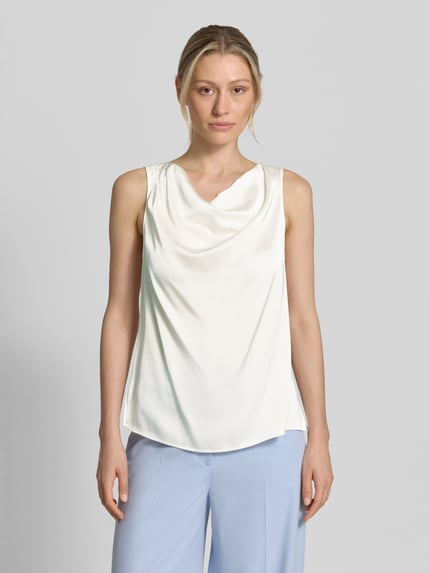 Frauenmodel trägt Blusentop mit Wasserfall-Ausschnitt von Comma, Material-Mix mit Viskose-Anteil, Regular-Fit, Drapierungen, cremefarben, Ganzkörperansicht von vorne.