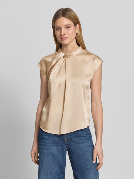 Vrouwenmodel draagt Blusenshirt aus Satin Modell 'Fleur' van Neo Noir in beige met drapering, regular fit, ronde hals, ruglengte maat 36: 58 cm, voorkantsopname bovenlichaam.