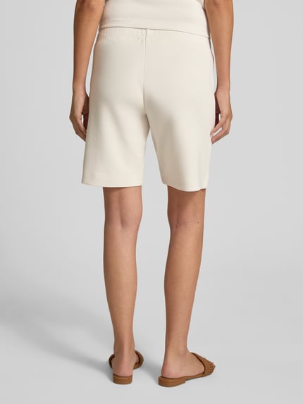 Vrouwenmodel draagt Regular Fit Shorts met elastische band van Christian Berg Woman in lichte kleur, elastische materiaalmix, ziernaden. Volledige lichaamsweergave achterkant.