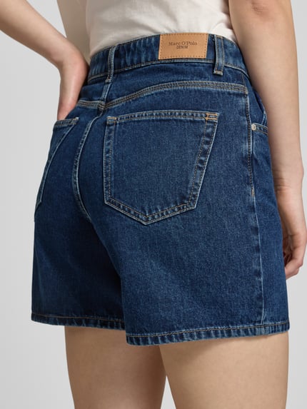Kobiece model prezentuje Bermuda Leg Jeansshorts aus reiner Baumwolle od Marc O'Polo Denim, denim, 5 kieszeni, detal label patch, widok całej sylwetki z tyłu