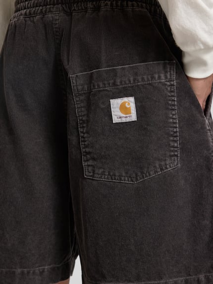 Männermodel trägt Carhartt Work In Progress Jeansshorts mit elastischem Bund Modell 'Reynold', strukturierte Baumwolle, Detailaufnahme Rückansicht.