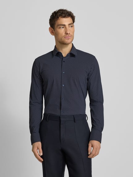 Männermodel trägt Slim Fit Businesshemd mit Allover-Muster Modell 'HANK' von BOSS, dunkel, Kentkragen, Ganzkörperansicht von vorne.