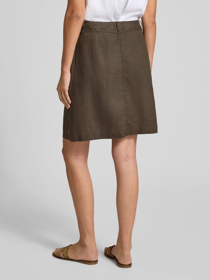 Frauenmodel trägt Minirock aus reinem Leinen Modell 'Rinea' von OPUS in A-Linie, braun, glatte Textur, Ganzkörperansicht Rückansicht, Bundweite 40 cm, Gesamtlänge 51 cm, seitlicher Reißverschluss, Schnürung.