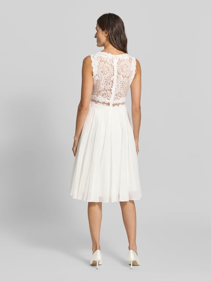 Frauenmodel trägt Cocktailkleid mit Spitze und Rundhalsausschnitt von Mascara, A-Linie, Chiffon, Midikleid, Rückenansicht, Ganzkörperansicht Rückansicht.